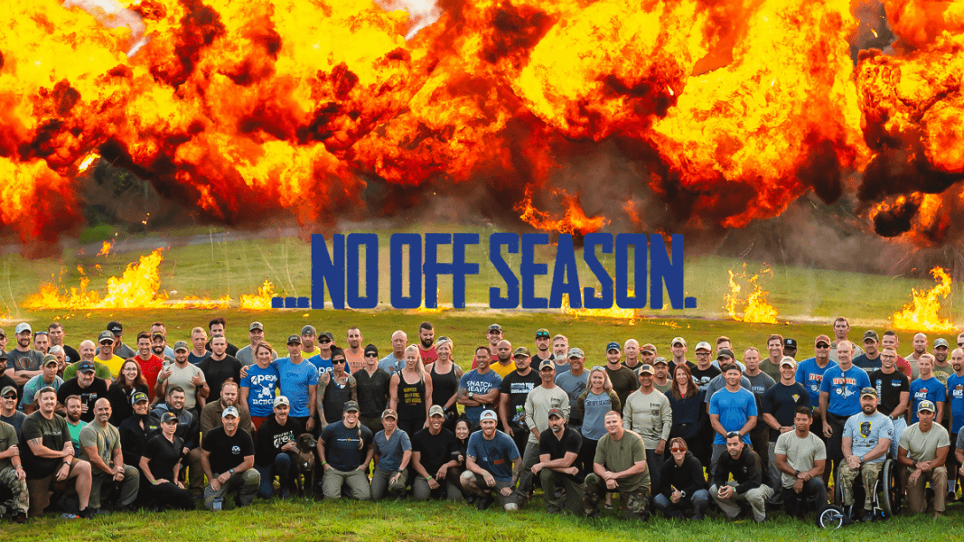 Large group of The Tactical Games athletes posing in front of large explosions in the background